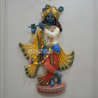 Colorful statue of a deity holding a flute on a white background